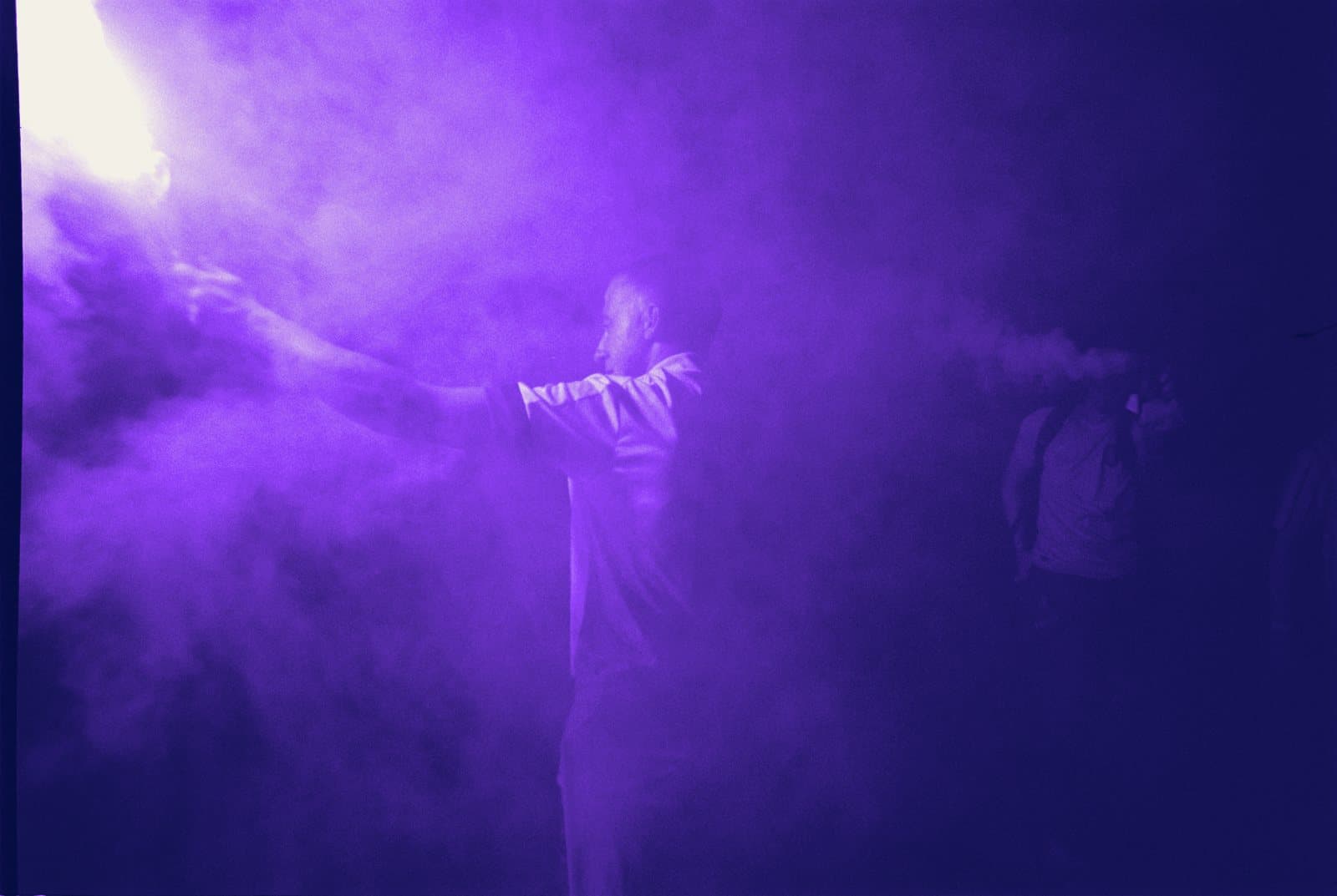 Fan wrapped in purple smoke from a flare